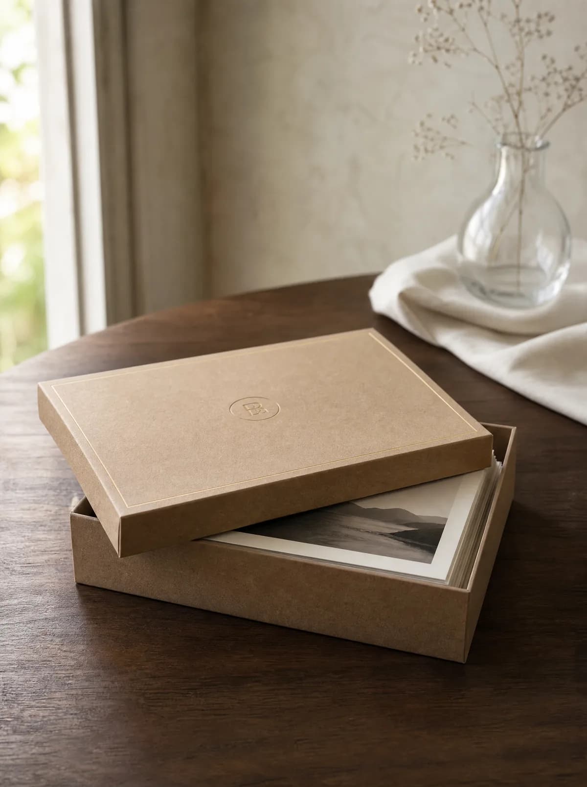 Craft-paper box with a gold hairline on a walnut table